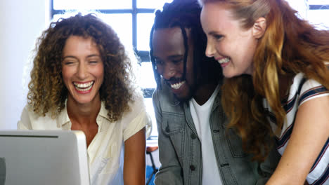colleagues looking at computer and discussing with each other