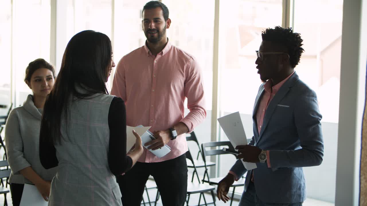 Young woman walking to colleagues and shaking hands