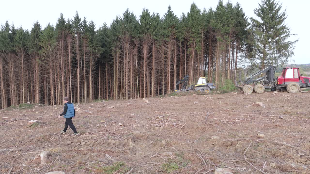 lonely male walking alone on a desolated land affected by deforestation causing global warming and climate change to planet earth