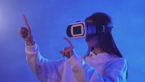 giovane donna che utilizza un auricolare vr su uno sfondo di luce al neon colorato