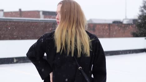 beautiful young blonde model posing for a photoshoot during a light snowfall in canada