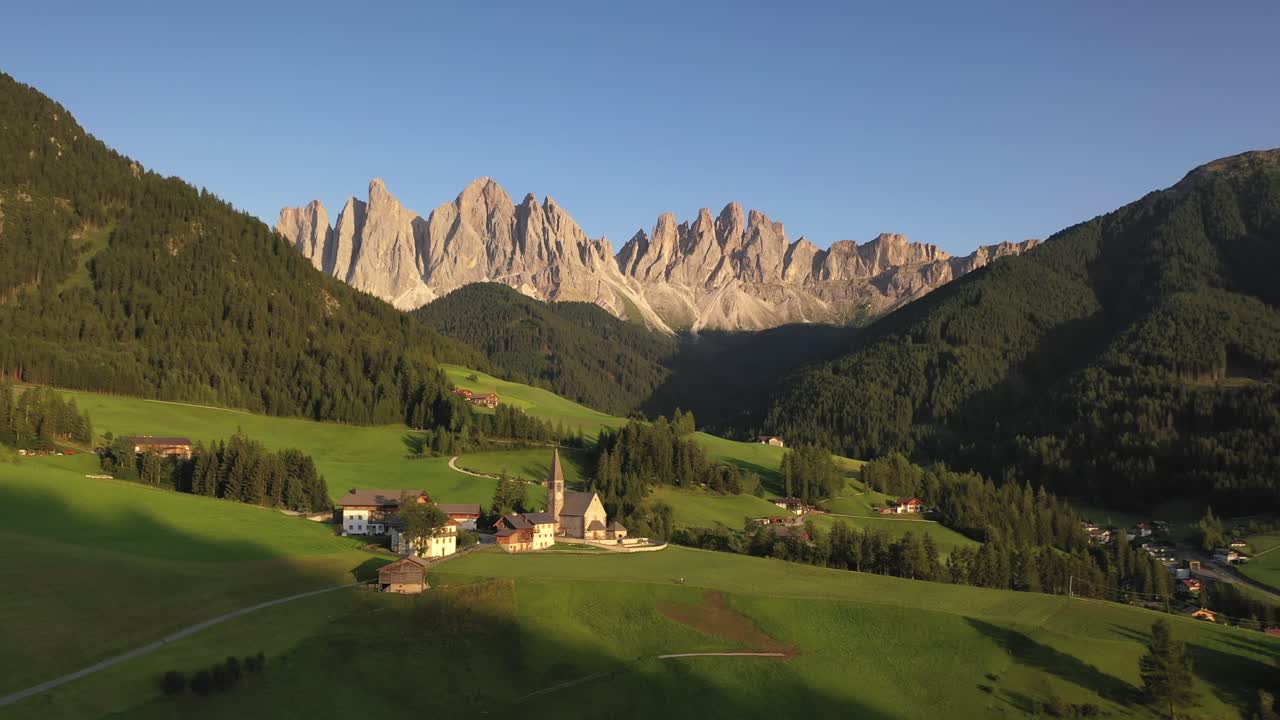 Santa Maddalena church with Odle mountain range in summer, aerial pull back shot