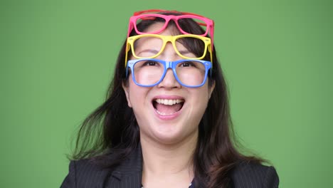 mature beautiful asian businesswoman wearing many eyeglasses as funny concept