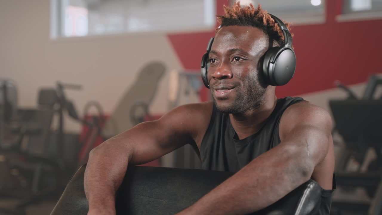 Man Relaxing in Gym with Headphones