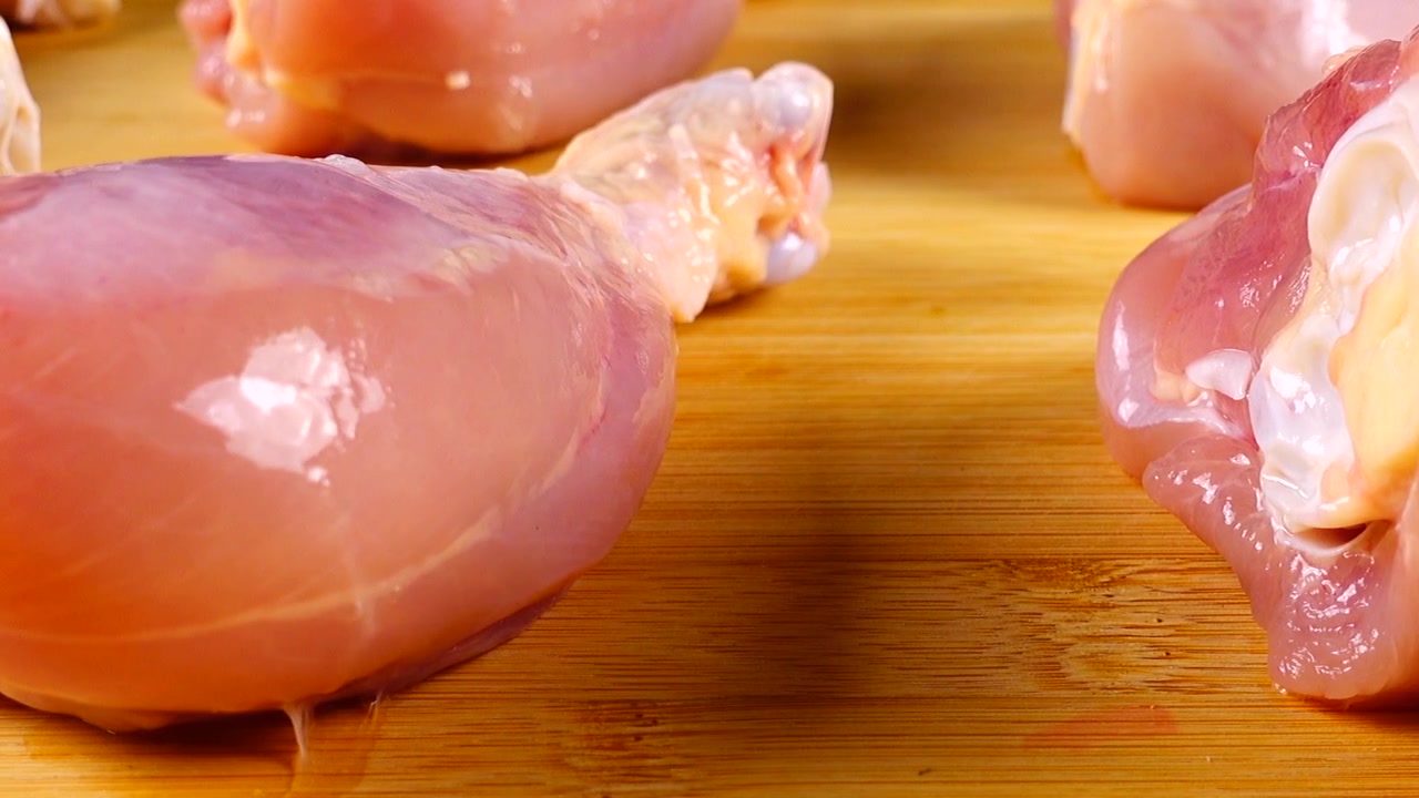 Cosce di pollo fresche su un tagliere