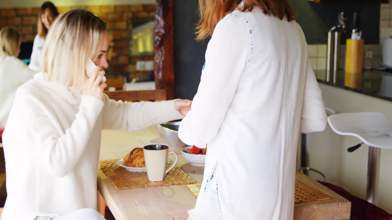 Lesbisk par spiser morgenmad i køkkenet 4k