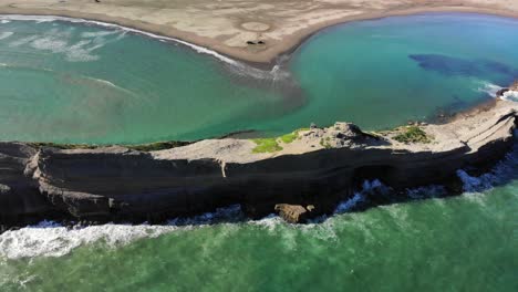 turquoise sea waves splashing on limestone reef in castlepoint, wairarapa coast of wellington in new zealand at summer