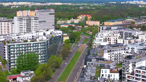 aerial view of obozowa street in warsaw’s wola district, showing modern apartment blocks, green spaces, and city roads on a bright summer day