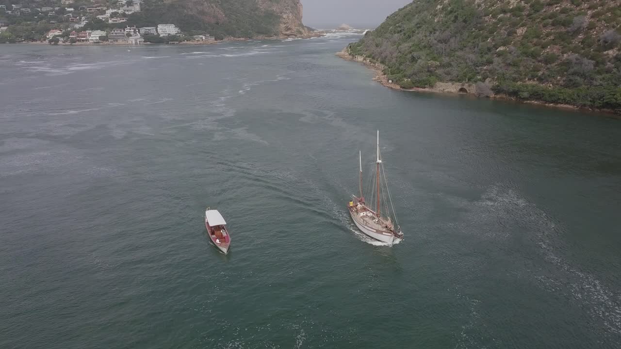 antena: velero y barco turístico en la laguna del puerto de knysna