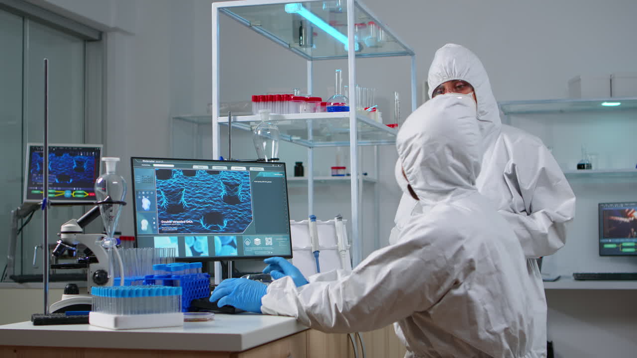 Team of scientists in coverall discussing about virus development