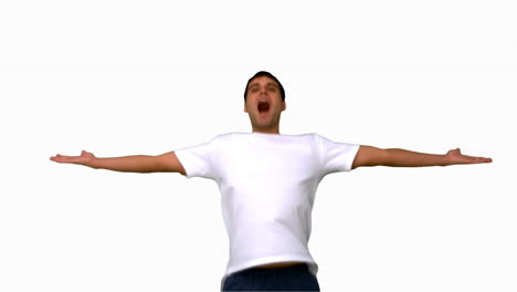 hombre guapo saltando y levantando los brazos en la pantalla blanca