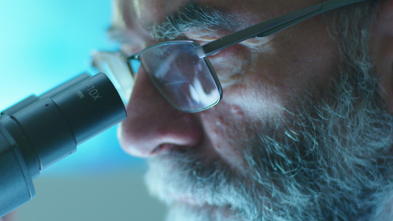 científico senior usando el microscopio