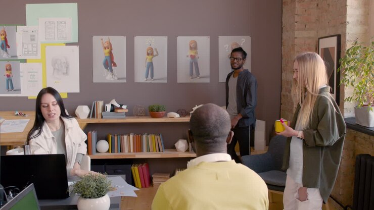 Multietnisk gruppe af grafiske designere holder et teammøde og brainstormer i et animationsstudie
