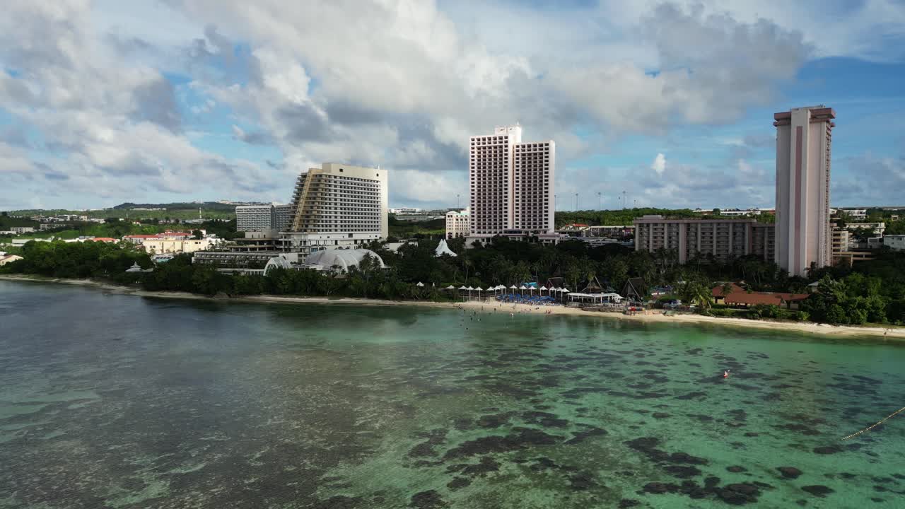 Scenic aerial view of Pacific Islands Club Guam Resort Hotel with lush greenery and stunning reef shoreline during daytime