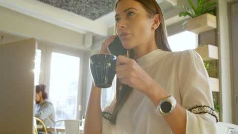 ejecutivo tomando café mientras habla por teléfono móvil 4k