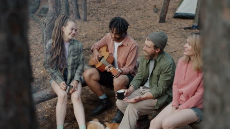 friends camping and playing guitar