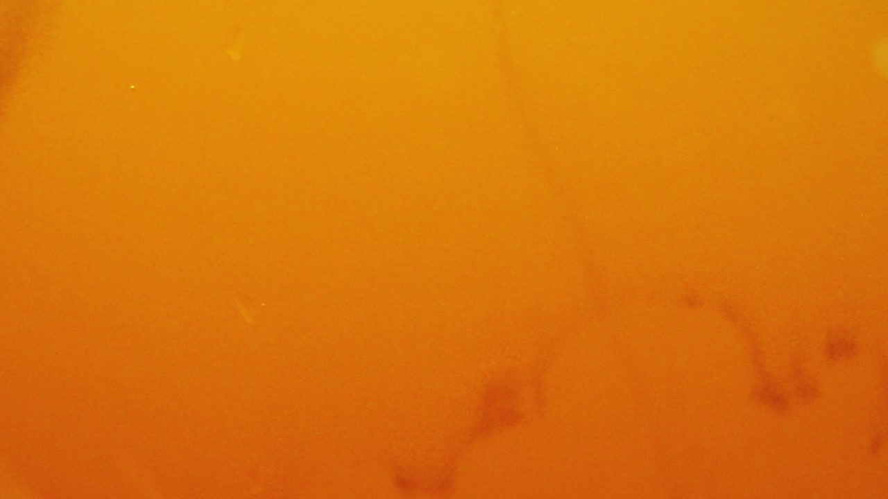 Syrup pouring into water with yellow background