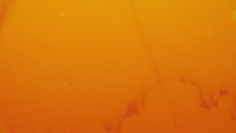 jarabe vertido en agua con fondo amarillo