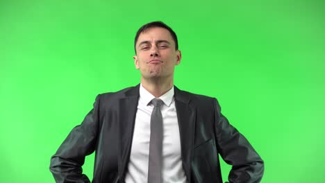 confident businessman standing in studio with hands on waist