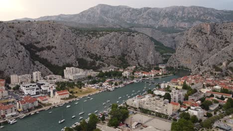 estuary in omis, croatia where cetina river mouth meets the sea at punta beachfront with dinara mountains background