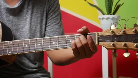 man's hand playing guitar