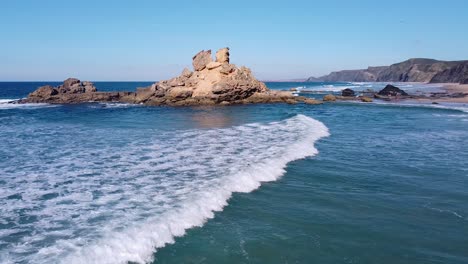 Un-Surfista-Remando-Hacia-Las-Olas-En-Una-Playa-En-Algarve,-Portugal