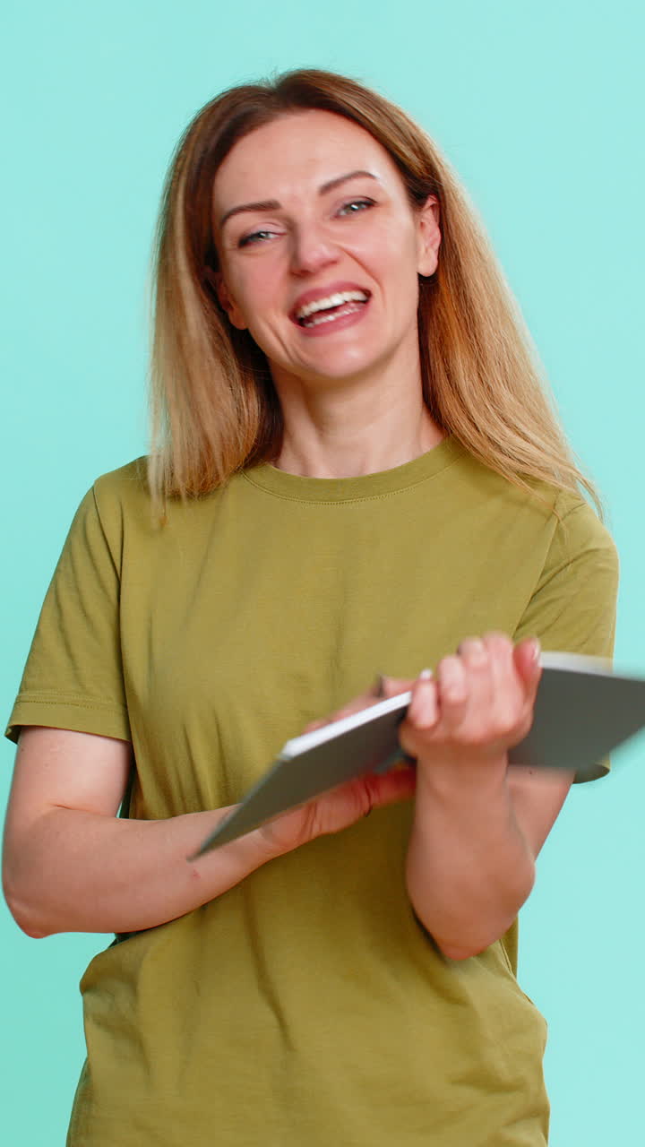Adult woman proudly showing notebook page with big word done written after completing important task