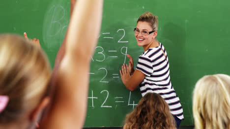 school kids raising hand in classroom