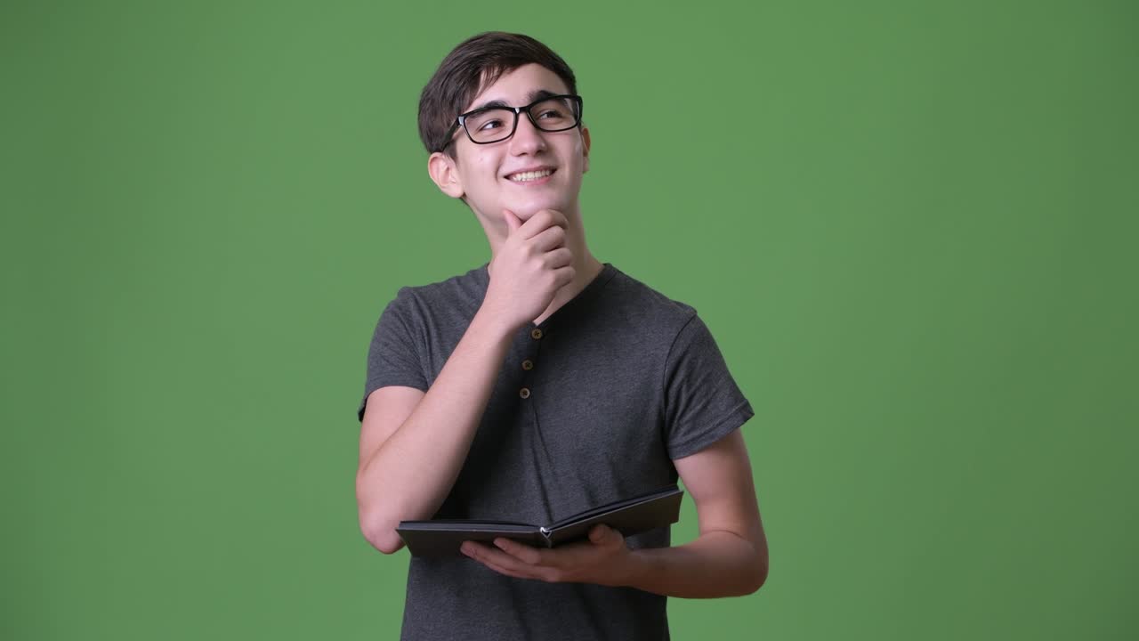 joven y guapo adolescente iraní contra un fondo verde