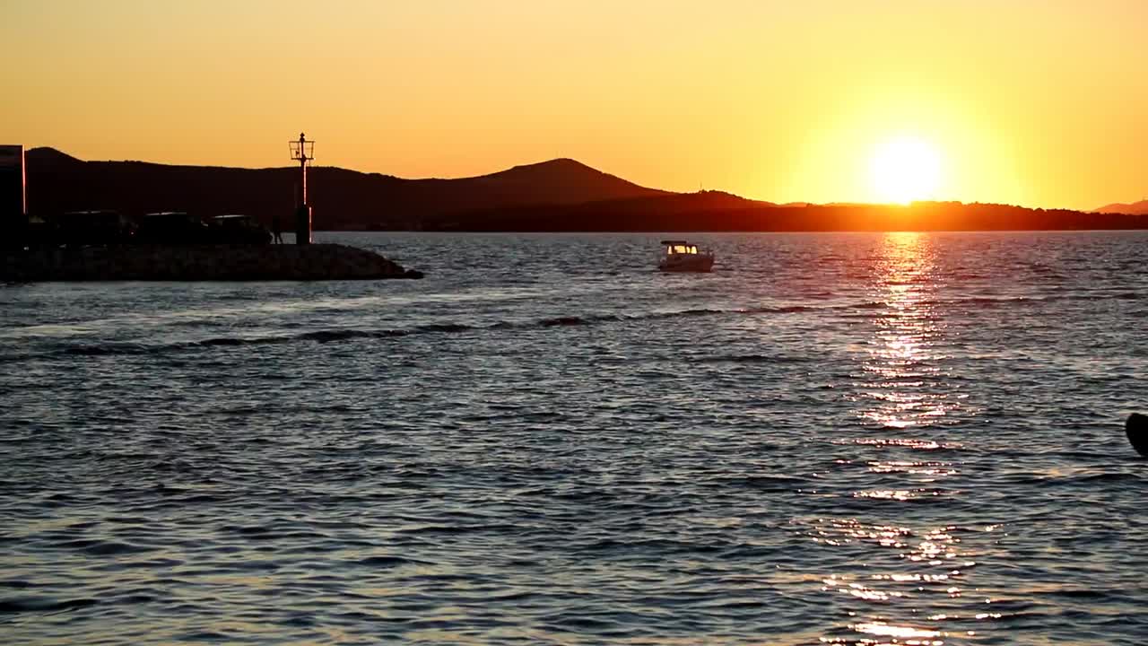 보트와 요트는 크로아티아 바이오그라드의 일몰 때 선착장에 들어가고 나옵니다.