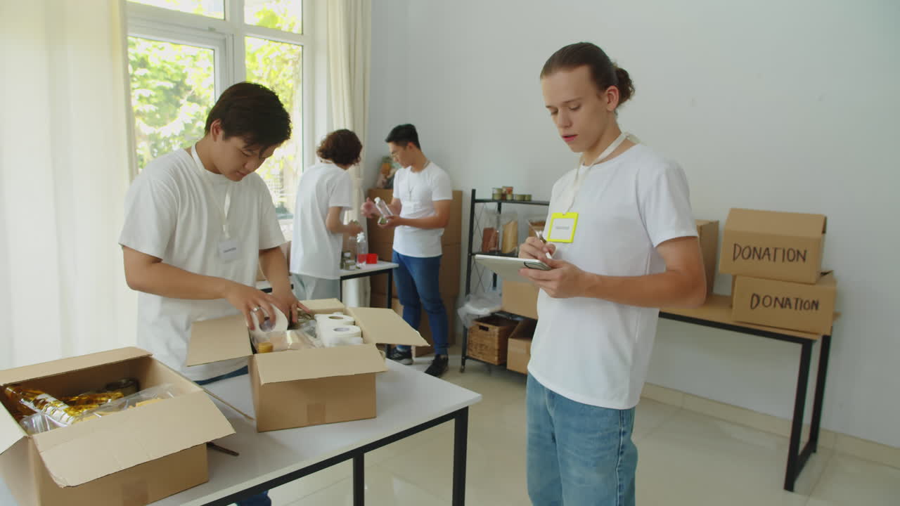 Charity Organization Manager Checking Donation Boxes Collected by Volunteers