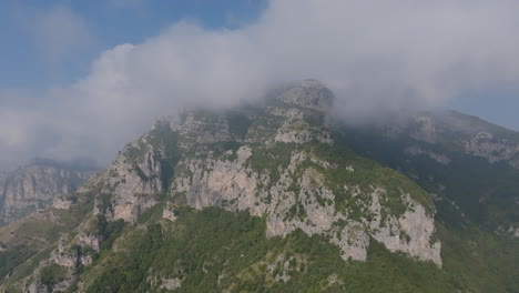 aerial footage flying towards the cloud covered tops of the mountains on the amalfi coast, italy