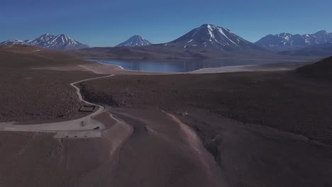 cinematic aerial view of lake miscanti in the andes, chile volcanos in the background, antofagasta region, bolivia