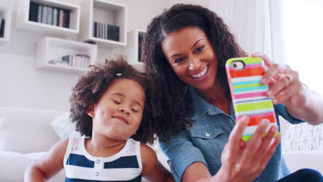 Young-black-woman-and-daughter-smiling-and-posing-to-selfie