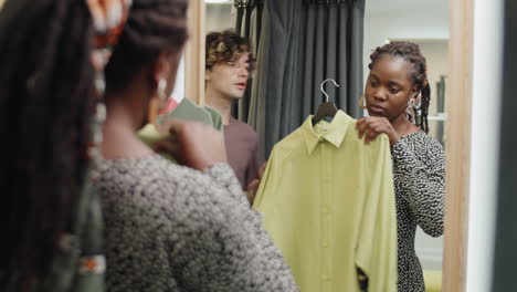 Assistant-Helping-Young-African-American-Woman-in-Dressing-Room