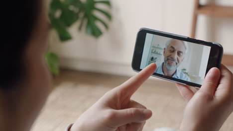 mujer joven usando un teléfono inteligente hablando en video con un abuelo sordo comunicándose usando lenguaje de señas gestos con las manos disfrutando de la comunicación en línea