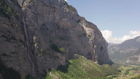 incline hacia abajo desde la ladera de la montaña hasta la pequeña ciudad en el valle verde