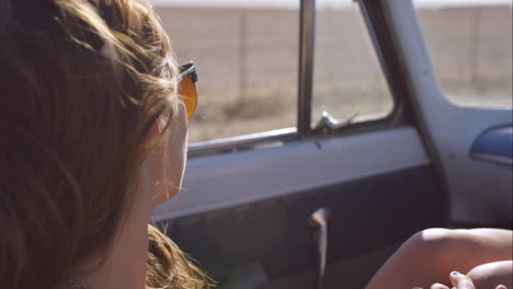 Schöne-Junge-Frau-Auf-Abenteuer-Roadtrip-In-Einem-Oldtimer-Cabrio-Und-Genießt-Den-Wind-In-Ihren-Haaren