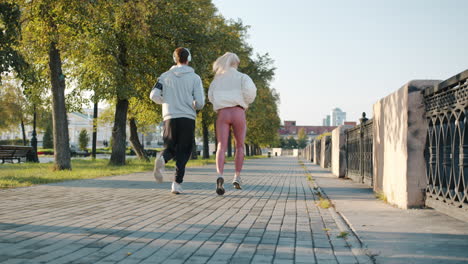 pareja corriendo en un parque de la ciudad