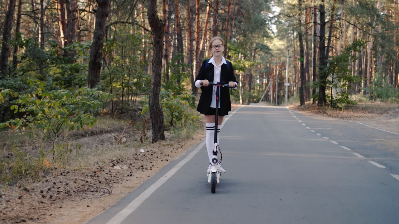교복을 입은 아이가 스쿠터를 타고 공원을 돌아다닌다