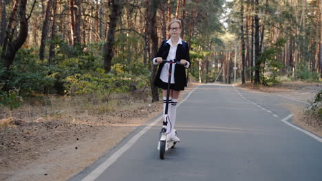 Un-Niño-Con-Uniforme-Escolar-Monta-Una-Scooter-Por-El-Parque