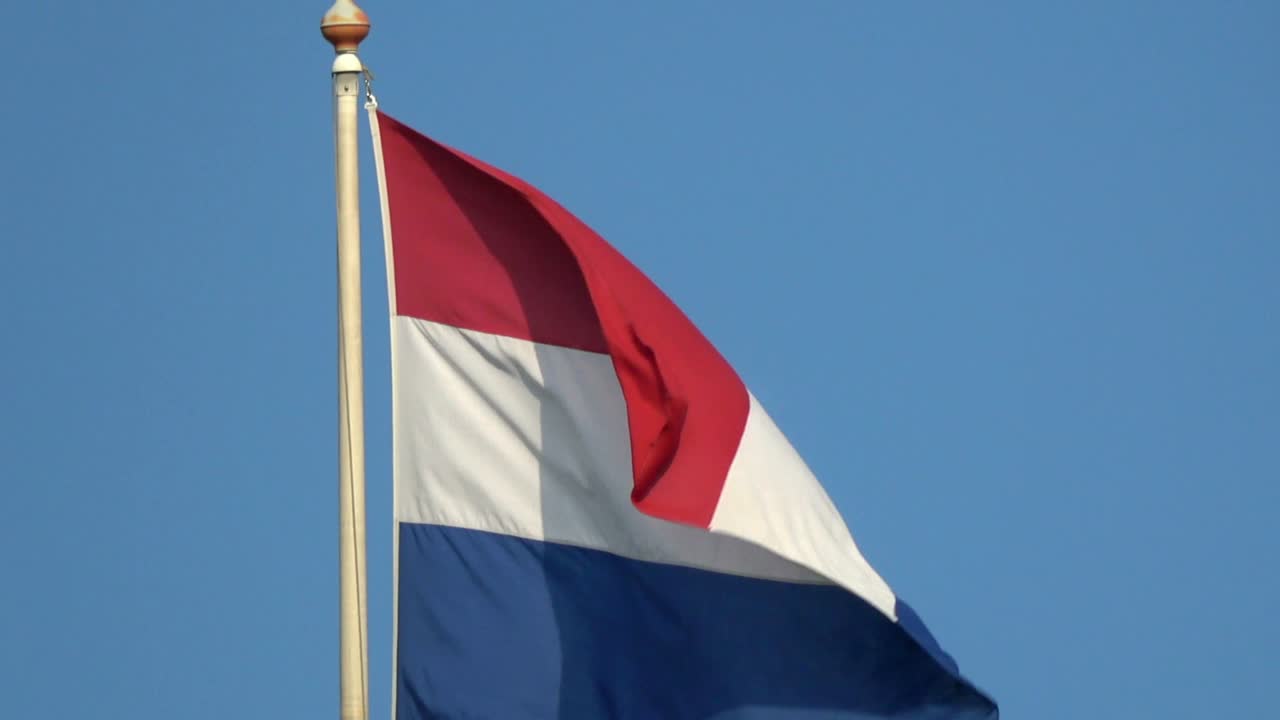4K. Flag of the Netherlands is waving in the blue sky. Dutch flag