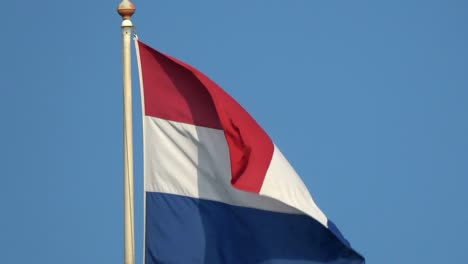4k. flag of the netherlands is waving in the blue sky. dutch flag