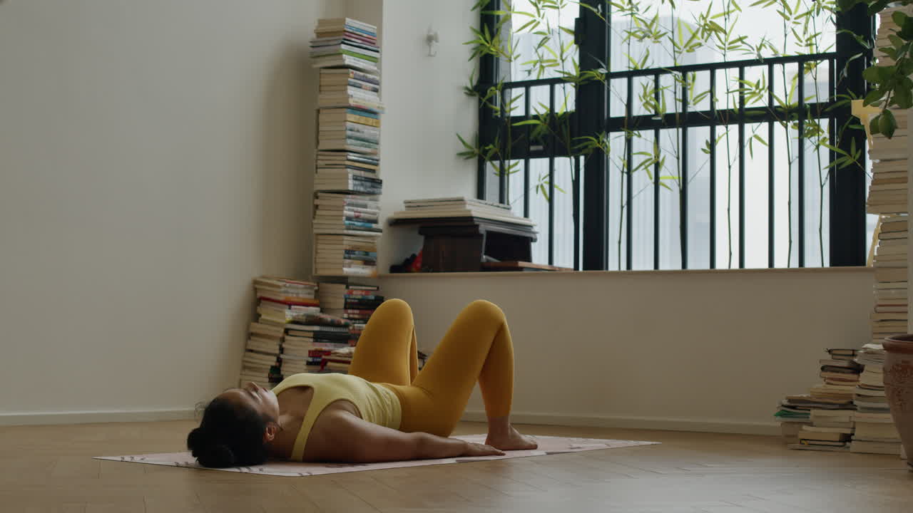 Woman performing a bridge pose yoga exercise at home
