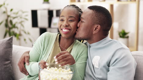 Popcorn,-kiss-and-couple-watching-tv-on-a-sofa