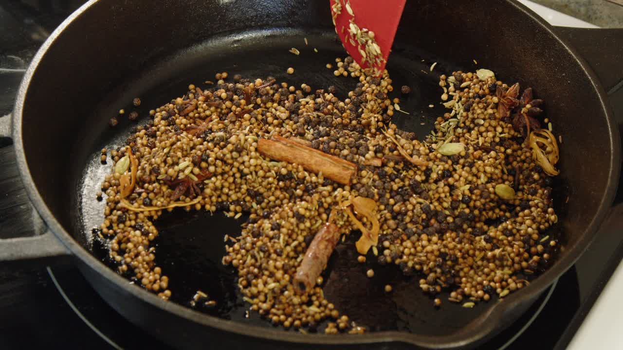 Whole spices toasted in cast iron pan, close-up Chettinad masala food