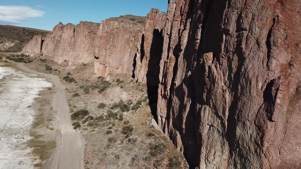 Drone Aerial View of Salt Flat in Canyon Under Dry Steep Cliffs of Patagonian Desert, Argentina