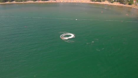 Drone-Volando-Sobre-El-Hombre-En-Jetski-En-El-Mar-De-Agua-Verde