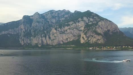 A-speedboat-on-a-lake-with-a-mountain-in-the-background,-Lake-Como,-Italy