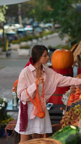 woman shopping for fruit at a street market